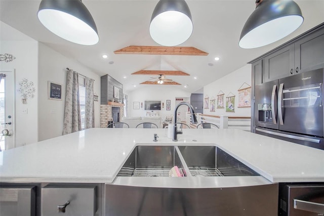 kitchen with stainless steel refrigerator with ice dispenser, ceiling fan, sink, and vaulted ceiling with beams