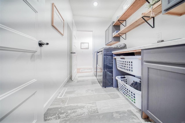 laundry area with washing machine and dryer and cabinets