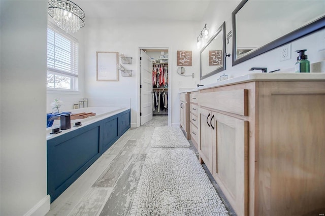 bathroom with vanity, a bathing tub, and wood-type flooring