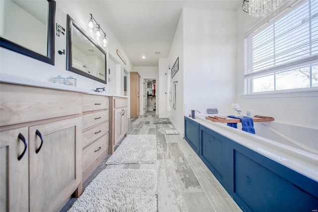 bathroom featuring vanity, hardwood / wood-style floors, and a bathtub