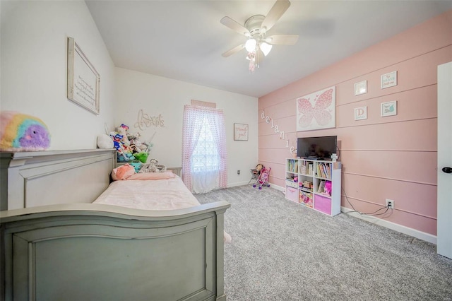 bedroom with carpet, wooden walls, and ceiling fan