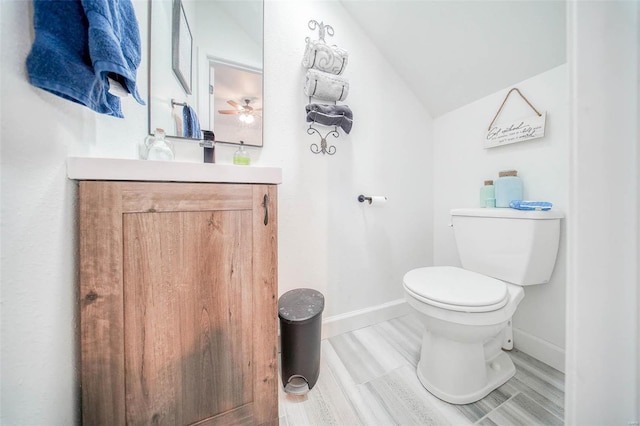 bathroom featuring hardwood / wood-style flooring, lofted ceiling, toilet, and vanity