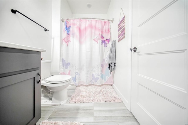 bathroom with vanity, a shower with shower curtain, and toilet