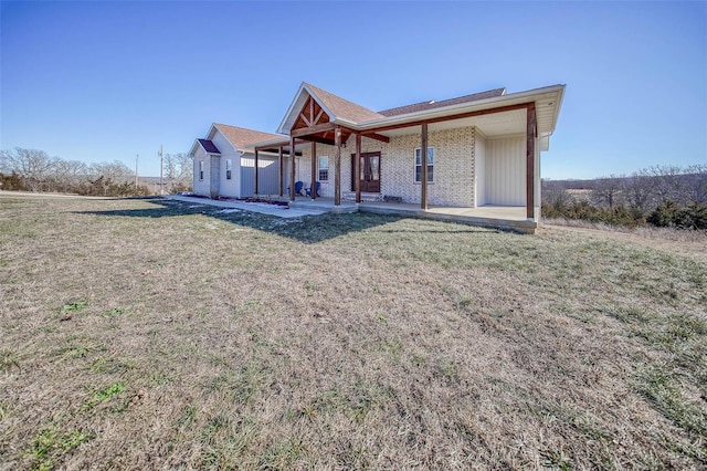 rear view of property with a patio and a lawn