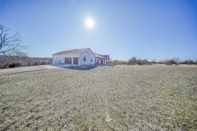 rear view of house with a garage and a yard