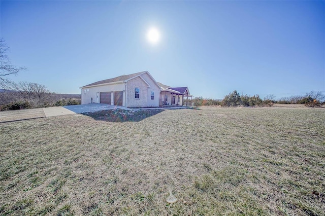 rear view of property with a yard and a garage