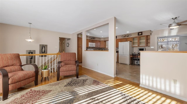 sitting room with ceiling fan and light hardwood / wood-style flooring