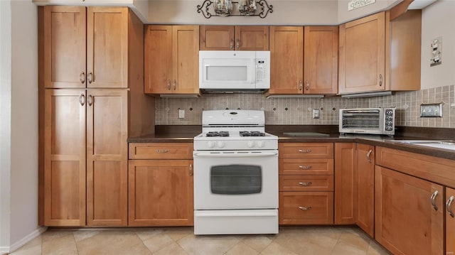 kitchen with light tile patterned floors, white appliances, and backsplash