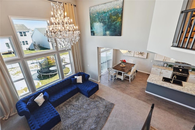 interior space with a healthy amount of sunlight, wood finished floors, a high ceiling, and an inviting chandelier