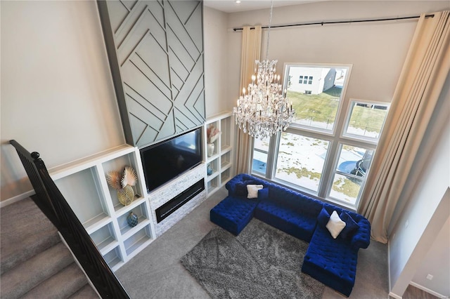 carpeted living room with a chandelier, stairway, and a high ceiling