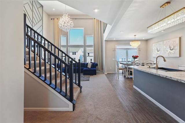 interior space featuring baseboards, wood finished floors, stairs, a notable chandelier, and recessed lighting