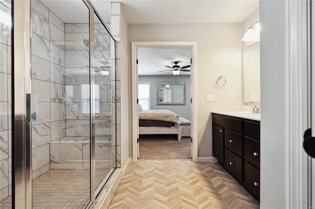 ensuite bathroom with ceiling fan, connected bathroom, vanity, baseboards, and a stall shower