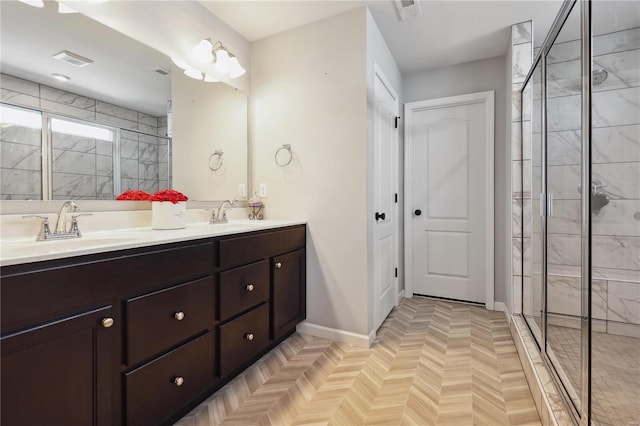 full bathroom featuring visible vents, a sink, a shower stall, and double vanity