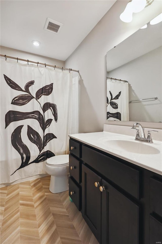 full bath featuring toilet, vanity, and visible vents