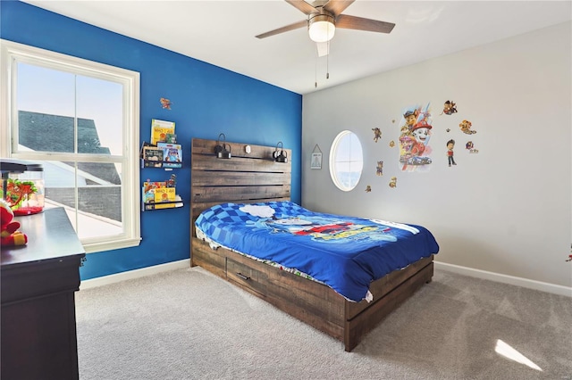 carpeted bedroom with a ceiling fan, multiple windows, and baseboards