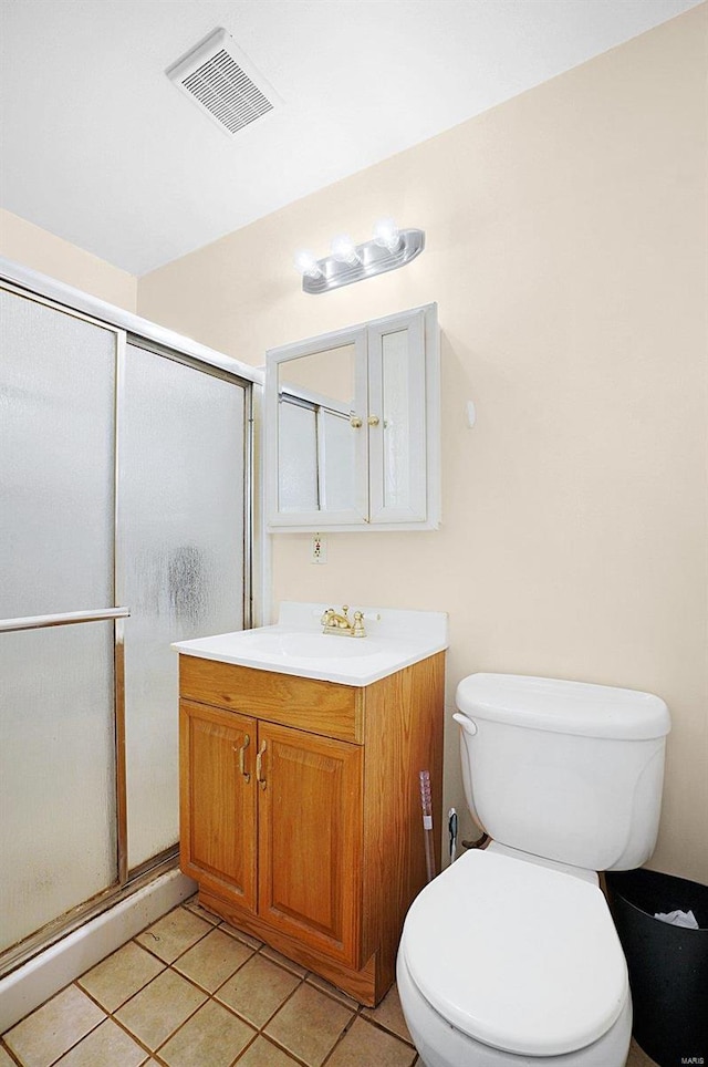 bathroom with tile patterned floors, vanity, toilet, and walk in shower