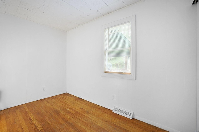 empty room featuring a healthy amount of sunlight and wood-type flooring