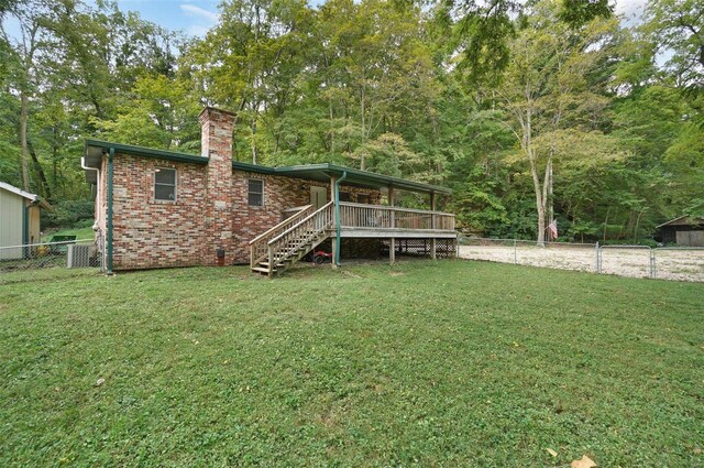 back of property featuring a wooden deck, a yard, and central AC unit