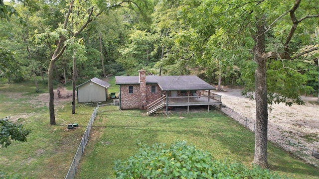 view of front facade featuring a front yard, a storage shed, and a wooden deck