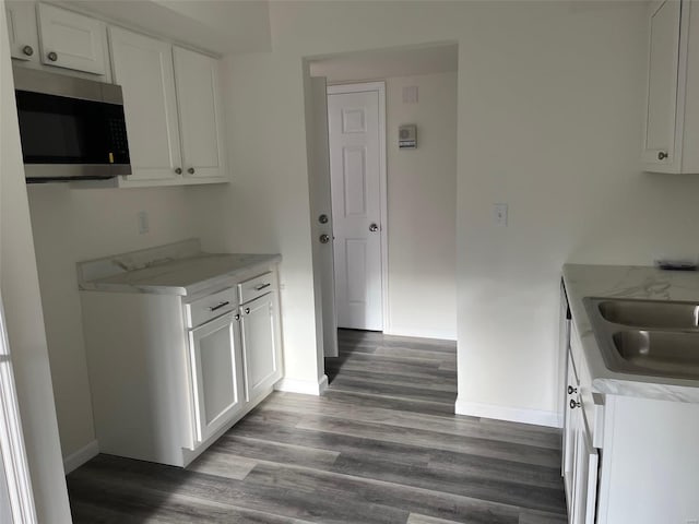 kitchen featuring dark hardwood / wood-style flooring, white cabinetry, and sink