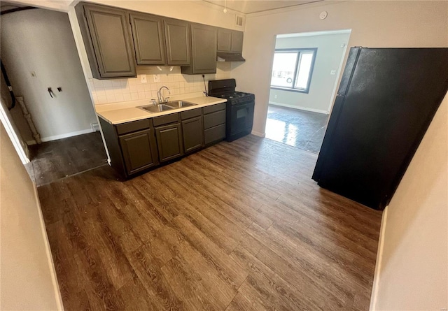 kitchen featuring dark brown cabinetry, sink, dark hardwood / wood-style flooring, decorative backsplash, and black appliances