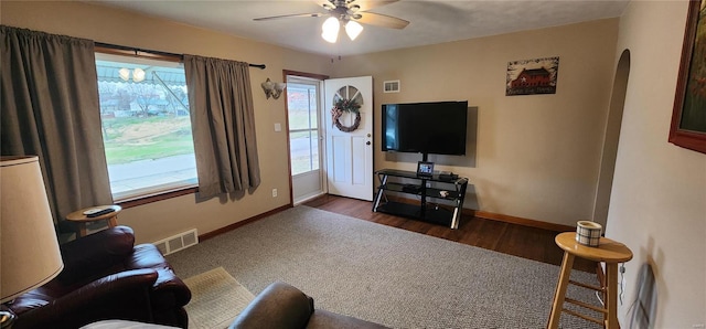 living room with dark hardwood / wood-style flooring and ceiling fan