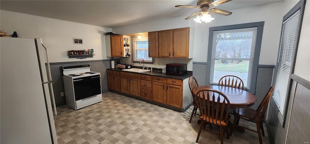 kitchen featuring tile walls, ceiling fan, sink, and white appliances