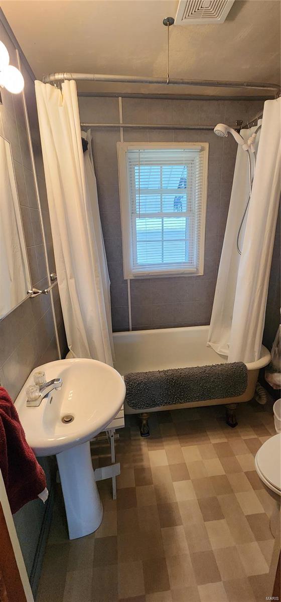 bathroom with shower / bath combo and toilet