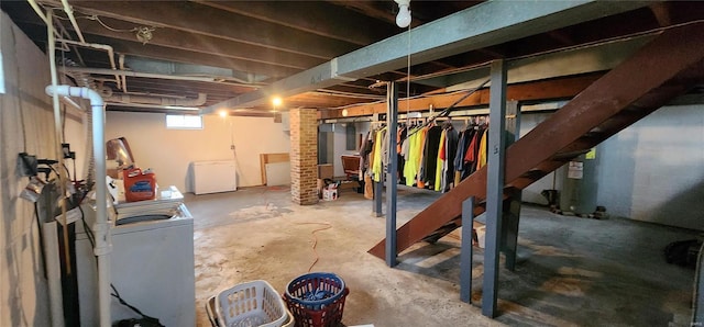 basement featuring washing machine and clothes dryer and fridge