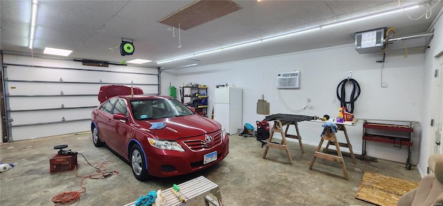 garage featuring white fridge and an AC wall unit