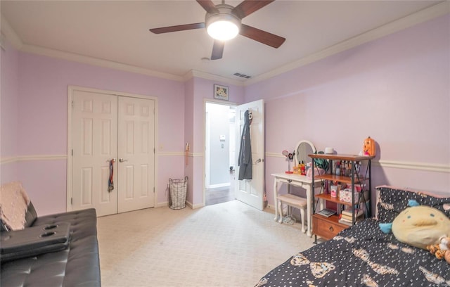 bedroom featuring a closet, ceiling fan, carpet, and ornamental molding