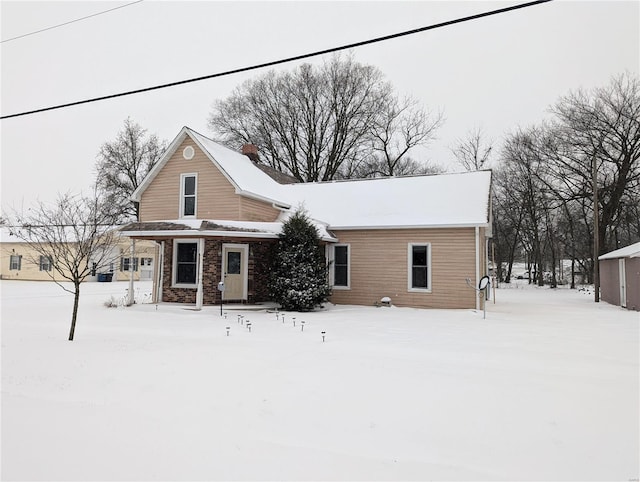 view of snow covered rear of property