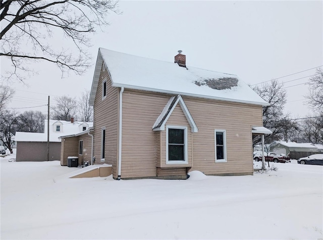 snow covered property with central AC unit