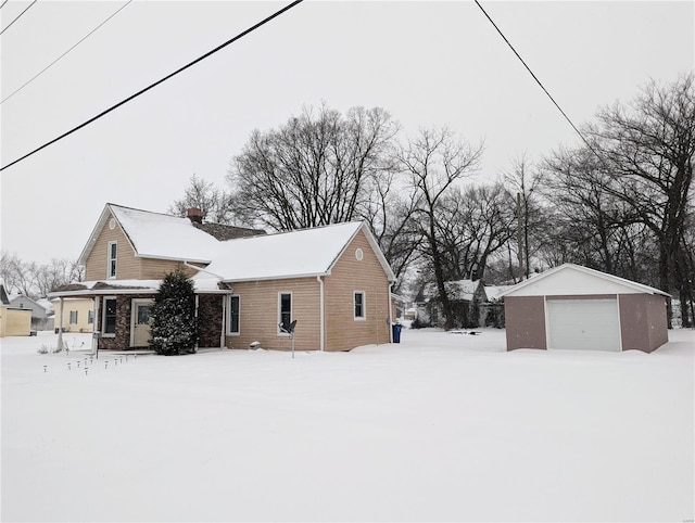 view of snow covered exterior with an outbuilding and a garage