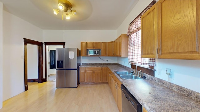 kitchen featuring ceiling fan, sink, stainless steel appliances, and light hardwood / wood-style flooring