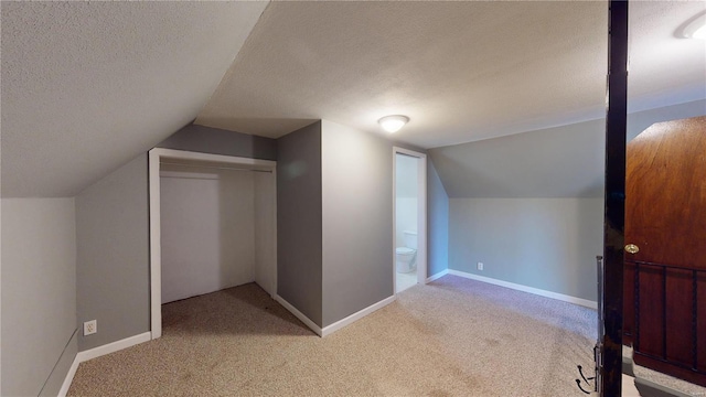 additional living space featuring lofted ceiling, light colored carpet, and a textured ceiling