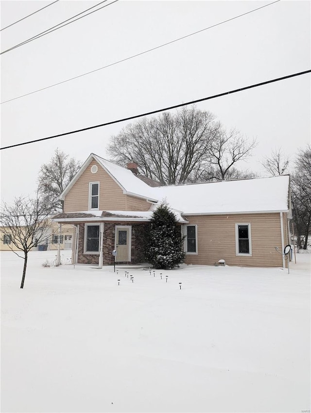 view of snow covered rear of property