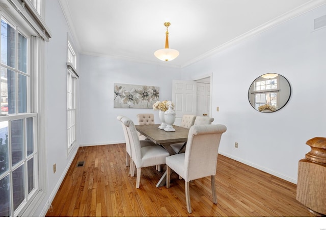 dining room featuring light wood-type flooring and ornamental molding