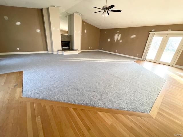 unfurnished living room featuring a tile fireplace and ceiling fan