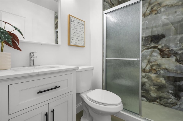 bathroom featuring walk in shower, vanity, and toilet