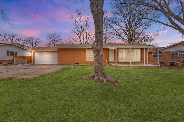 single story home featuring a yard and a garage