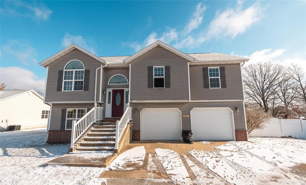 split foyer home featuring a garage and cooling unit