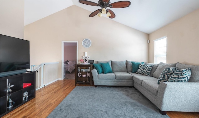 living room with hardwood / wood-style floors, ceiling fan, and lofted ceiling