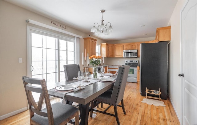 dining area featuring light hardwood / wood-style flooring and an inviting chandelier