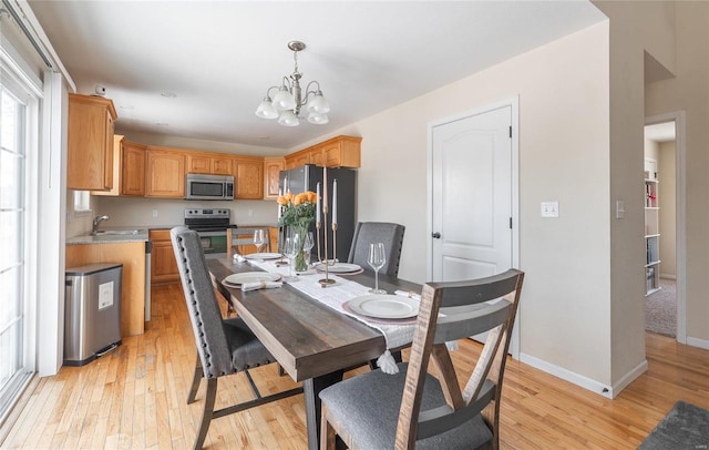 dining space with a notable chandelier and light hardwood / wood-style floors