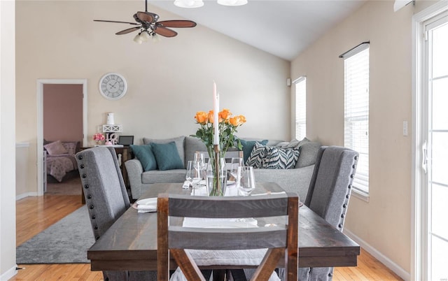 dining room with light hardwood / wood-style floors, ceiling fan, and lofted ceiling