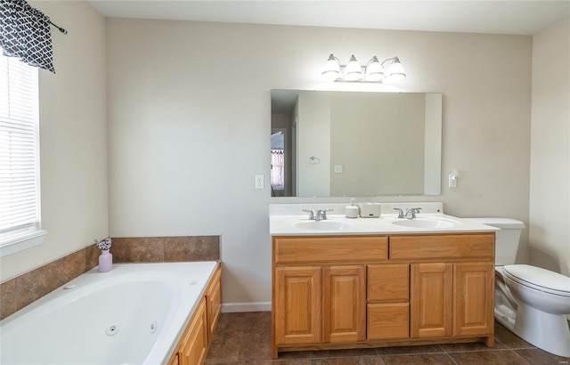 bathroom with vanity, toilet, and a tub