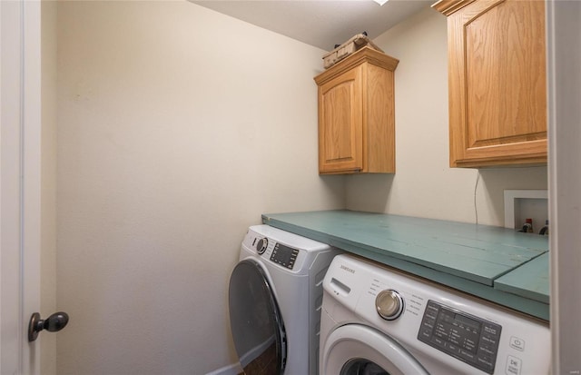 laundry area featuring separate washer and dryer and cabinets