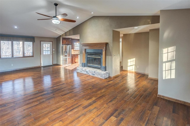 unfurnished living room featuring ceiling fan, lofted ceiling, dark hardwood / wood-style floors, and a fireplace