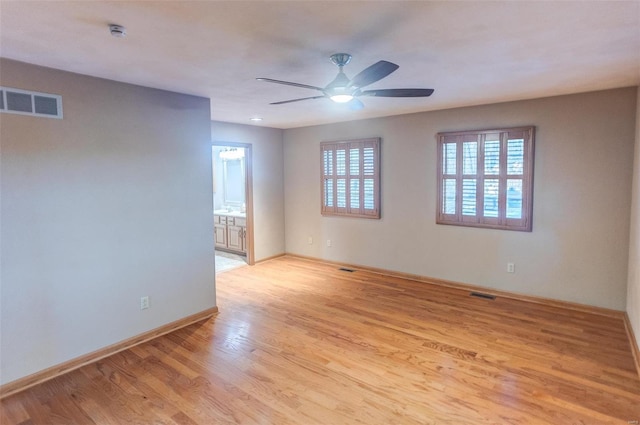 empty room with ceiling fan and light hardwood / wood-style floors